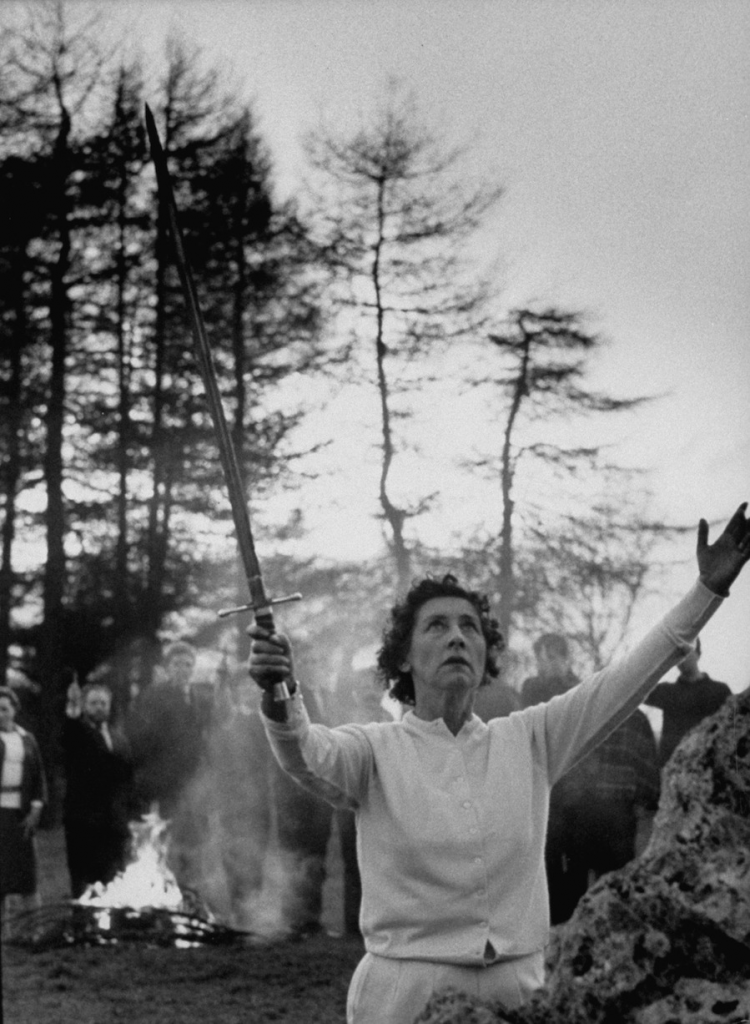 EB holding sword upwards in stone circle